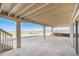Covered back porch with a concrete patio and stairs leading to the yard at 1222 S County Road 185, Byers, CO 80103