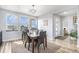 Dining area features a dark wood table, leather chairs, and natural light from three windows at 1222 S County Road 185, Byers, CO 80103