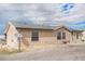 Beige home with vinyl siding, a satellite dish, and a partially graveled yard at 1222 S County Road 185, Byers, CO 80103