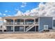 Blue home featuring a large back porch and a partially finished yard at 1222 S County Road 185, Byers, CO 80103
