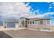 Beautiful blue two-story home with stone accents, three car garage, and a concrete driveway at 1222 S County Road 185, Byers, CO 80103