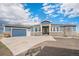 Beautiful blue two-story home with stone accents, three car garage, and a concrete driveway at 1222 S County Road 185, Byers, CO 80103
