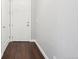 Bright hallway featuring dark wood-look flooring and a white paneled entry door at 336 E 1St Ave # 207, Denver, CO 80203