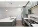 Modern kitchen featuring stainless steel appliances, gray cabinets, stylish pendant lights, and a white countertop at 336 E 1St Ave # 207, Denver, CO 80203