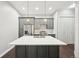 Spacious kitchen island with white countertop, stainless steel appliances, modern lighting, and gray cabinets at 336 E 1St Ave # 207, Denver, CO 80203