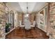 Inviting dining room featuring hardwood floors, stone accents, ample natural light, and a dining table for four at 9797 Sunset Hill Cir, Lone Tree, CO 80124