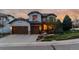 Charming two-story home with a three-car garage, stone accents, manicured lawn, and inviting landscaping at 9797 Sunset Hill Cir, Lone Tree, CO 80124