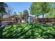 A spacious backyard features a well-maintained lawn, mature trees, storage shed and an open patio at 12378 E Cedar Cir, Aurora, CO 80012