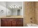 Bathroom featuring a granite vanity, mirror, and tiled shower, offering a stylish and functional space at 12378 E Cedar Cir, Aurora, CO 80012