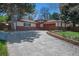 Charming single-story home featuring a red front door and lush landscaping at 12378 E Cedar Cir, Aurora, CO 80012