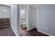 Hallway leading to bathroom with tiled floors, open shelving, and a glimpse of the bathroom's vanity and fixtures at 12378 E Cedar Cir, Aurora, CO 80012