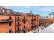 Exterior view of an urban brick building with metal balconies, fire escapes and a cityscape backdrop at 1745 Wazee St # 5E, Denver, CO 80202