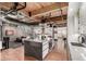 Open-concept kitchen with a central island, seamlessly connecting to the living area and staircase at 1745 Wazee St # 5E, Denver, CO 80202