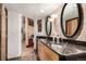 Double sink main bathroom featuring modern cabinets, stone accent wall and walk in closet at 1745 Wazee St # 5E, Denver, CO 80202