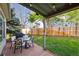 Inviting backyard featuring a covered deck with dining set, green lawn, and wood fence for privacy at 12705 Home Farm Dr, Westminster, CO 80234