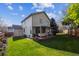 Expansive backyard showcasing a covered deck, well-kept lawn, and the home's exterior at 12705 Home Farm Dr, Westminster, CO 80234