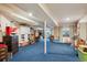 Large finished basement featuring blue carpeting, exposed ceiling beams, and multiple functional areas at 12705 Home Farm Dr, Westminster, CO 80234