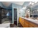 Bathroom featuring double sinks, wood cabinets, glass-enclosed shower, and natural light at 12705 Home Farm Dr, Westminster, CO 80234