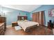 Spacious bedroom featuring dark hardwood floors, cozy bed, sconces, and warm lighting, creating a relaxing space at 12705 Home Farm Dr, Westminster, CO 80234