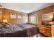 Comfortable bedroom with a cozy bed, dark wood floors, dresser, and warm inviting colors at 12705 Home Farm Dr, Westminster, CO 80234