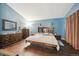 Comfortable bedroom with hardwood floors, a cozy bed, sconces, and warm lighting creating a relaxing space at 12705 Home Farm Dr, Westminster, CO 80234
