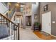 Elegant foyer featuring a staircase with wrought iron spindles, wood accents, and a decorative niche at 12705 Home Farm Dr, Westminster, CO 80234