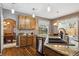 Well-appointed kitchen showcasing stainless steel appliances, granite counters, wood cabinets, and a view to the backyard at 12705 Home Farm Dr, Westminster, CO 80234