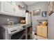 Well-organized laundry room with modern washer and dryer, ample cabinet storage, and decorative accents at 12705 Home Farm Dr, Westminster, CO 80234