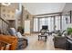Bright living room featuring a vaulted ceiling, large windows, comfortable seating, and an open entryway at 12705 Home Farm Dr, Westminster, CO 80234