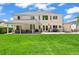 View of a large manicured backyard featuring a patio with an outdoor kitchen, furniture, and green lawn at 6566 S Telluride St, Aurora, CO 80016