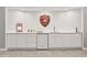 Basement bar area with white cabinets, sink, mini fridge, and bar-themed decor at 6566 S Telluride St, Aurora, CO 80016