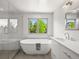 Bright bathroom features a soaking tub, walk-in shower, and double vanity with modern fixtures and large window at 6566 S Telluride St, Aurora, CO 80016