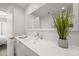 Bright bathroom with a large mirror, white cabinets, and a decorative plant at 6566 S Telluride St, Aurora, CO 80016