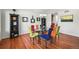Modern dining room with glass table, colorful chairs, hardwood floors, and decorative shelving at 6566 S Telluride St, Aurora, CO 80016