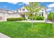 Charming two-story home with lush green lawn, mature trees, and well-manicured landscaping at 6566 S Telluride St, Aurora, CO 80016