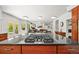 Modern kitchen featuring a gas stove top on a black granite island, open to living area, and a door to backyard at 6566 S Telluride St, Aurora, CO 80016