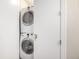 A stacked washer and dryer in a laundry closet behind a white door at 2650 Front View # 205, Denver, CO 80211