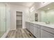 Modern bathroom with double vanity, quartz countertop, walk-in shower, and a view into the walk-in closet at 2877 E 103Rd Dr, Thornton, CO 80229