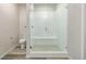 The bathroom features a glass-enclosed walk-in shower with a bench, paired with a sleek toilet at 2877 E 103Rd Dr, Thornton, CO 80229