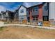 Modern townhome exteriors feature unique color schemes and a small fenced yard at 2877 E 103Rd Dr, Thornton, CO 80229