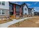 Townhome exteriors are built with stone and vinyl siding, complimented by a small fenced yard at 2877 E 103Rd Dr, Thornton, CO 80229