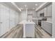 Well-lit kitchen featuring an island with a sink, stainless steel appliances, and gray cabinets at 2877 E 103Rd Dr, Thornton, CO 80229