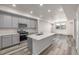 Bright kitchen with stainless steel appliances, island with sink, and gray cabinets at 2877 E 103Rd Dr, Thornton, CO 80229