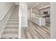 Open concept living space with stairs leading to upper level and view into the kitchen at 2877 E 103Rd Dr, Thornton, CO 80229
