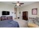 Spacious bedroom with a cozy sitting area and a television on top of a dresser with drawers at 15046 Verbena St, Thornton, CO 80602
