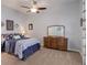 Cozy bedroom featuring a full sized bed with floral pattern linens, a ceiling fan, and a dresser with mirror at 15046 Verbena St, Thornton, CO 80602