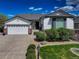 Charming single-story home with a well-manicured lawn, stone accents, and attached two car garage at 15046 Verbena St, Thornton, CO 80602