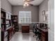 Well-lit home office featuring custom built-ins, desk and drawers and a ceiling fan and light fixture at 15046 Verbena St, Thornton, CO 80602