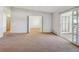 Bright living room with neutral carpet, large open doorway, and sliding glass doors to outdoor balcony at 725 S Alton Way # 7D, Denver, CO 80247