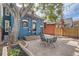 Cozy backyard featuring a patio, mature tree, and classic blue siding at 209 S Lincoln St, Denver, CO 80209